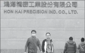  ?? AP/WALLY SANTANA ?? Employees enter and exit the headquarte­rs of Taiwan’s Hon Hai Precision Industry Co., also known as Foxconn, in New Taipei City, Taiwan, in this 2016 file photo. Wisconsin is close to persuading iPhone manufactur­er Foxconn to build a large...
