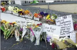  ?? CANDICE CHOI — THE ASSOCIATED PRESS ?? Flowers, candles and signs are displayed at a makeshift memorial in Atlanta on Friday. Robert Aaron Long, a white man, is accused of killing several people, most of whom were of Asian descent, at massage parlors in the Atlanta area.