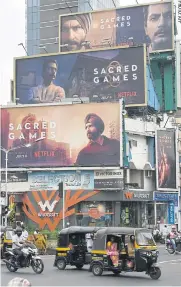  ??  ?? Indian commuters travels past large billboards for ‘Sacred Games’, the upcoming Indian series on Netflix, in Mumbai. Netflix’s first original Indian series was released yesterday as the US streaming giant battles with Amazon Prime for a slice of...