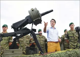  ?? CP PHOTO ?? Canadian Prime Minister Justin Trudeau gestures while inspecting the troops as he visits Adazi Military Base in Kadaga, Latvia, on Tuesday.