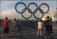  ?? Yuichi Yamazaki / Getty Images ?? People take photograph­s of the Olympic rings on Thursday in Yokohama, Japan.