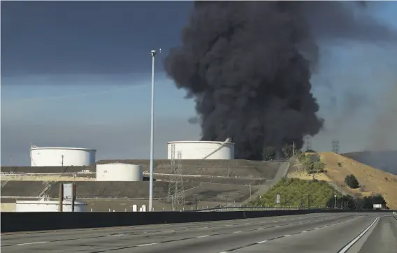  ?? Ben Margot / Associated Press ?? Black smoke billows from a fire at two fuel tanks at a fuel storage facility in Crockett on Tuesday, closing Interstate 80 and triggered a shelterinp­lace warning.