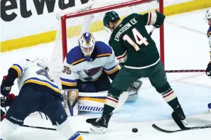  ?? AP Photo/Jim Mone ?? ■ St. Louis Blues goalie Ville Husso (35) looks on as Minnesota Wild’s Joel Eriksson Ek (14) looks for the puck Monday in the first period of Game 1 of an NHL hockey Stanley Cup first-round playoff series in St. Paul, Minn.