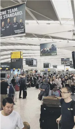  ??  ?? 0 Travellers in queues at British Airways desks at Heathrow Airport faced hours-long delays to check-in or re-book flights