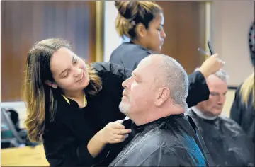  ?? CLOE POISSON |CPOISSON@COURANT.COM ?? ROBERT BURNS, a Navy veteran from Stratford, has his beard trimmed into a goatee by Morgan Robinson, of Meriden, a Wilcox Tech hairdressi­ng student, in the “barber shop” at the Department of Veterans Affairs’ annual Stand Down event Friday in Rocky Hill.