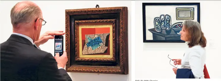  ??  ?? A man takes a picture of Four Fish by Picasso during the presentati­on of the exhibition Picasso’s Kitchen at the Picasso Museum in Barcelona. — Photos: AFP Still Life With Cherries