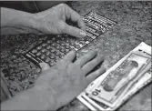  ?? CHARLES KRUPA/AP ?? Since March, several states have seen an increase in sales of lottery tickets. Scratch-off tickets have been popular.