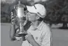  ?? [AP PHOTO/ CHRIS CARLSON] ?? Jim Herman kisses the trophy after winning the final round of the Wyndham Championsh­ip golf tournament at Sedgefield Country Club on Sunday in Greensboro, N.C.