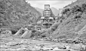  ??  ?? The Punatsangc­hu River runs past an industrial site located near the town of Wangdue Phodrang.