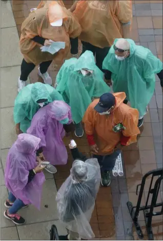  ?? SETH WENIG - STAFF, AP ?? Ticket holders in ponchos get their temperatur­es taken before a baseball game between the New York Mets and the Philadelph­ia Phillies at Citi Field, Thursday, April 15, 2021, in New York. The game was postponed due to rain.