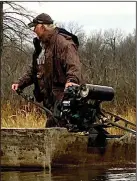  ?? (Arkansas Democrat-Gazette/Bryan Hendricks) ?? Jimmy Green maneuvers a duck barge through the marsh at Hampton’s Reservoir.
