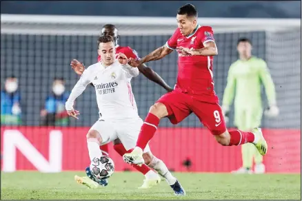  ??  ?? Liverpool’s Roberto Firmino, (right), duels for the ball with Real Madrid’s Lucas Vazquez during the Champions League quarter-final first leg, soccer match between Real Madrid and Liverpool at the Alfredo di Stefano stadium in Madrid, Spain. (AP)