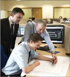  ??  ?? Pat Ryan, Padraig Harty and John Fleming examine some technical plans in the Dairymaste­r Design Department.