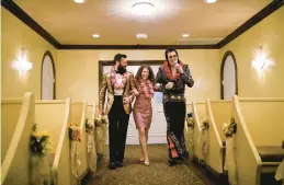  ?? JOHN LOCHER/AP ?? Elvis impersonat­or Brendan Paul, right, walks Katie Salvatore and Eric Wheeler down the aisle during a wedding ceremony at the Graceland Wedding Chapel in Las Vegas.
