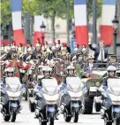  ??  ?? > New French President Emmanuel Macron, right, waves to the crowds, as he is transporte­d up the ChampsElys­ees Avenue in Paris