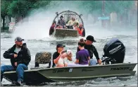  ?? RICK WILKING / REUTERS ?? People are rescued by boat on Sunday in Dickinson from devastatin­g flooding caused by Tropical Storm Harvey. Thousands have fled since Harvey hit as a hurricane on Friday.