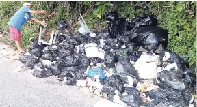  ?? PHOTO BY GARETH DAVIS SR ?? A resident dumping garbage along the roadway at Breastwork­s in Port Antonio, Portland, last Tuesday.