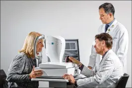  ?? MATT MILLER / WASHINGTON UNIVERSITY SCHOOL OF MEDICINE / TNS ?? Dr. Gregory Van Stavern (seated) and Dr. Rajendra Apte examine the eyes of a woman using technology that may make it possible to screen patients for Alzheimer’s disease years before symptoms begin.