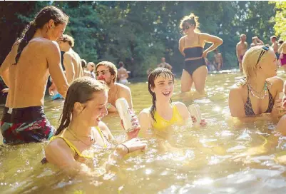  ?? AFP ?? People take a dip on the riverbank at Hackney Marshes in east London on Saturday amid the coronaviru­s outbreak in the United Kingdom. Just days after the lockdown ended, a heatwave hit Britain with temperatur­es touching 40 degrees Celsius.