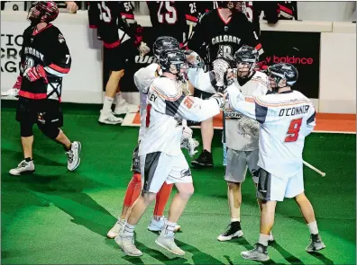  ?? SARAH GORDON/THE DAY ?? Kevin Crowley of the New England Black Wolves (21) celebrates his goal with teammates during Sunday’s NLL game against the Calgary Roughnecks at Mohegan Sun Arena. The Black Wolves won 13-12 won in overtime.