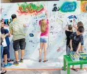  ?? PHOTO COURTESY OF JAMI NIX RAHN ?? Residents add to the graffiti wall that was part of the recent Celebrate the Arts Day atWeston Town Center.