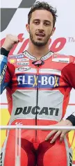  ??  ?? Pugno Andrea Dovizioso sul podio di Sepang e, a destra, in azione durante il Gp della Malesia