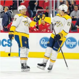  ?? THE ASSOCIATED PRESS ?? Nashville Predators defenseman Roman Josi, left, congratula­tes left wing Scott Hartnell on Hartnell’s goal against the Detroit Red Wings on Tuesday in Detroit.