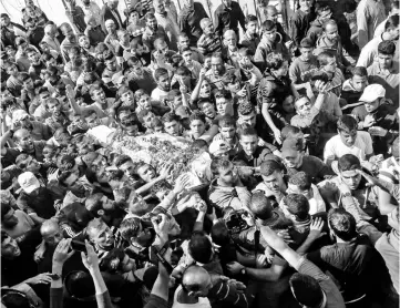  ?? — AFP photo ?? Mourners carry the body of 19-year-old Palestinia­n Nassar Abu Taim, who was killed the day before amid clashes following a protest at the Israel-Gaza border fence, during his funeral in Khan Yunis in the southern Gaza Strip.