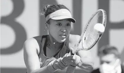  ?? CHRISTOPHE ENA/AP ?? Japan’s Naomi Osaka returns the ball to Romania’s Patricia Maria Tig during their first round match of the French Open in Paris on May 30. Osaka later withdrew from the tournament, citing concern for her mental health.