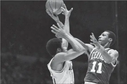  ?? ASSOCIATED PRESS FILE ?? In this file photo, Boston Celtics guard Charlie Scott (11) goes flying toward the basket as Los Angeles Lakers’ Norm Nixon.