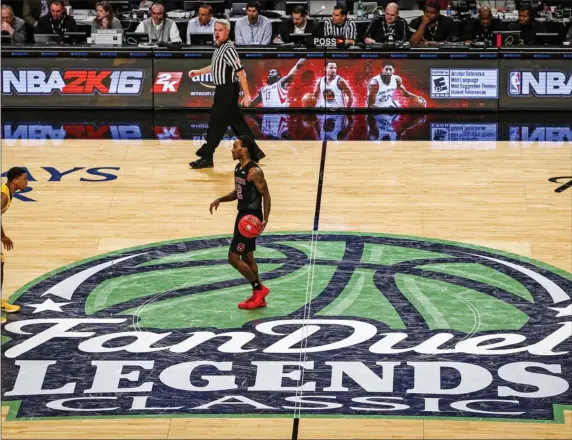  ?? KATHY WILLENS, FILE — THE ASSOCIATED PRESS ?? North Carolina State player crosses half court and the Fan Duel sports betting logo. Mobile bets tip off Friday.