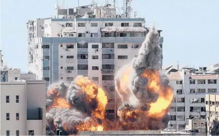  ?? MAHMUD HAMS/GETTY-AFP ?? A ball of fire erupts from a building housing various media outlets, including The Associated Press, after an Israeli airstrike Saturday in Gaza City. The ongoing fighting has killed at least 145 Palestinia­ns and eight Israelis.