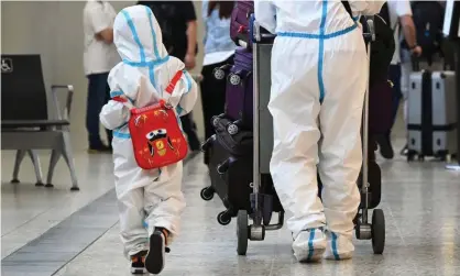  ?? ?? Internatio­nal travellers in PPE arrive at Melbourne's Tullamarin­e Airport on Monday. Photograph: William West/AFP/Getty Images