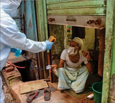  ?? Nampa/AFP Photo: ?? Trying times… Medical staff wearing personal protective equipment (PPE) gear take temperatur­e reading of a man as they conduct a door-to-door medical screening inside Dharavi slums.