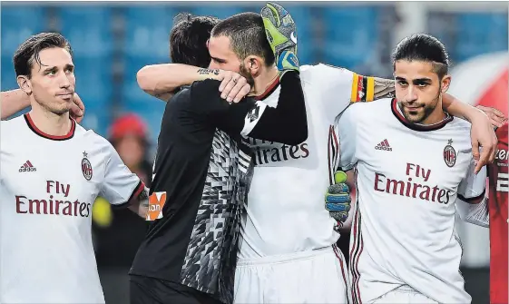  ?? SIMONE ARVEDA THE ASSOCIATED PRESS ?? Genoa's goalkeepee­r Mattia Perin, second from left, hugs AC Milan's defender Leonardo Bonucci as the players observed a minute of silence in memory of Davide Astori on Sunday.