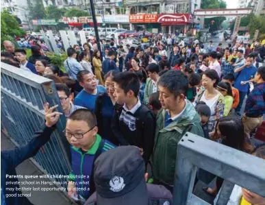  ??  ?? Parents queue with children outside a private school in Hangzhou in May, what may be their last opportunit­y to attend a good school