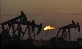  ?? Photograph: David Goldman/AP ?? A flare burns off methane and other hydrocarbo­ns as oil pumpjacks operate in the Permian basin in Midland, Texas.