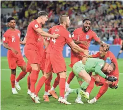  ?? DAN MULLAN/GETTY IMAGES ?? England goalie Jordan Pickford is mobbed by teammates after beating Colombia in a penalty shootout.