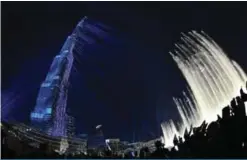  ??  ?? A picture shows people posing for a selfie during a laser show at Burj Khalifa, the tallest tower in the world, to mark the New Year’s eve celebratio­ns in Dubai.