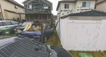  ?? AZIN GHAFFARI ?? Cars and houses show the impact of the recent hail storm in Saddle Ridge.