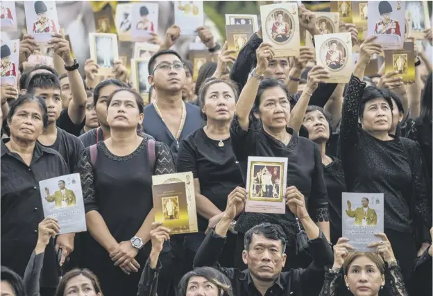  ??  ?? People display images of the late Bhumibol Adulyadej in the ancient royal capital Ayutthaya . Thais were asked to observe 89 seconds of silence at 3:52pm