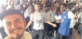  ??  ?? > Dylan Jones, 19, from Neath with students during a sexual health session in a school in Zambia