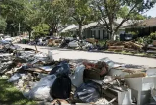  ?? MATT ROURKE — THE ASSOCIATED PRESS FILE ?? In this file photo, flood damaged debris from homes lines the street in the aftermath of Hurricane Harvey in Houston. One month after Harvey dumped record rainfall in the Houston area, many neighborho­ods and suburbs of the nation’s fourth largest city...