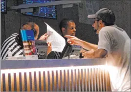  ?? Wayne Parry The Associated Press ?? A gambler places a sports bet at Bally’s in Atlantic City in September 2019. Participan­ts in a sports betting conference on Tuesday agreed that holes in budgets due to the coronaviru­s outbreak could spur more states to allow sports wagering.