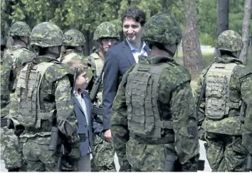  ?? THE CANADIAN PRESS FILES ?? Canadian Prime Minister Justin Trudeau and his son Xavier review an honour guard as they arrive at the Internatio­nal Peacekeepi­ng and Security Centre in Yavoriv, Ukraine in 2016. Trudeau has finally unveiled Canada’s long- awaited commitment to UN peacekeepi­ng efforts, and it’s getting mixed reviews.