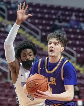  ?? Emily Matthews/Post-Gazette ?? Jake DiMichele, driving past Constituti­on’s Yasir Gaither, led OLSH with 21 points, 16 rebounds and 5 blocked shots.