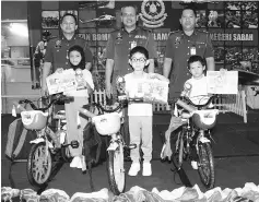  ??  ?? Nordin (centre) and his officers with the winner in the Kelab 3K colouring competitio­n.