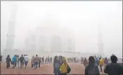  ??  ?? Tourists visiting Taj Mahal, enveloped in fog in Agra.