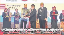  ??  ?? Dato’ Sri Ismail Sabri Yaakob menyampaik­an Anugerah Kepimpinan ASEAN Kali Ke-3 pada wakil eBario sempena Mesyuarat Ke-10 Menteri-menteri ASEAN Mengenai Pembanguna­n Luar Bandar dan Pembasmian Kemiskinan (AMRDPE).