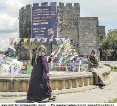  ?? Ilyas Akengin / AFP ?? Banderas del Partido Democrátic­o Popular (HDP) y una pancarta electoral con la imagen del presidente turco, Recep Tayyip Erdogan, colgado en el histórico Castillo de Sur , en el centro histórico de Diyarbakir.